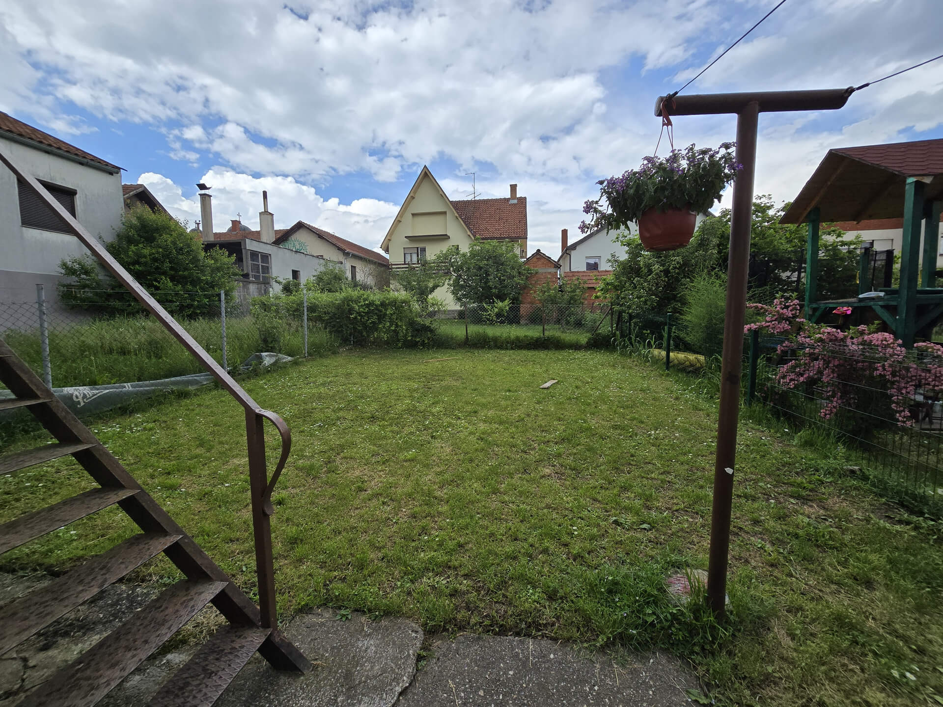 Dvorište koje se nalazi iza kuće i stepenice koje vode iznad pomoćne zgrade