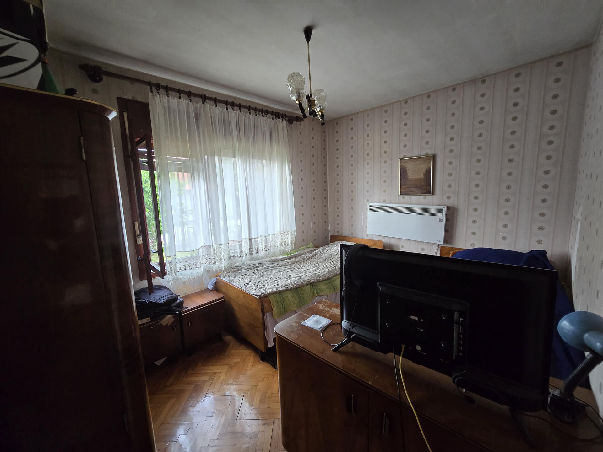 Spavaća soba sa tv, dva kreveta i ormarom