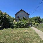 Kuća sa dvorištem i dosta zelenila, betonska staza koja vodi od kapije do ulaza