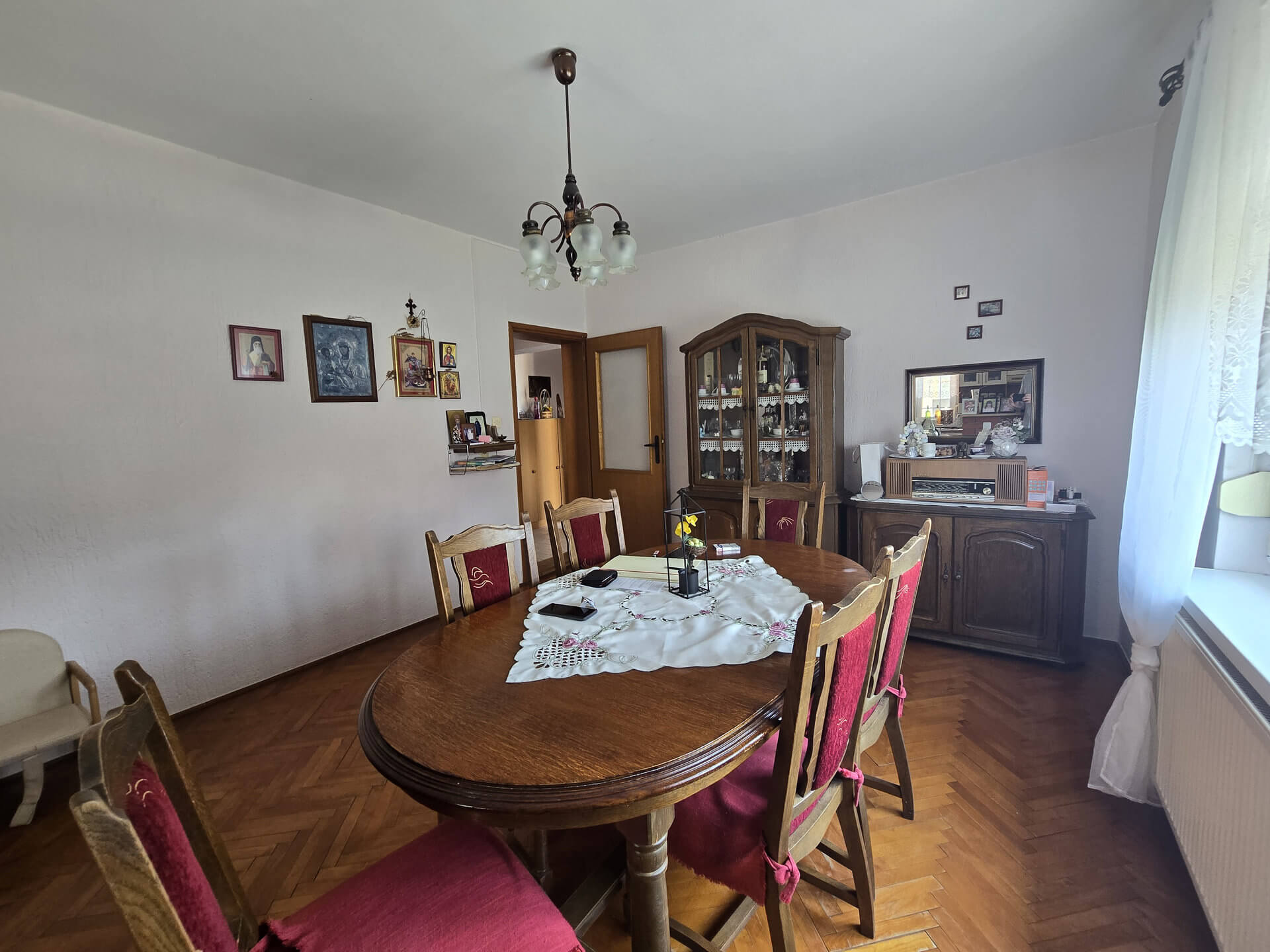 Trpezarijski sto na sredini velike prostorije, regal